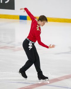 A young skater stands ready to perform his ice skating routine